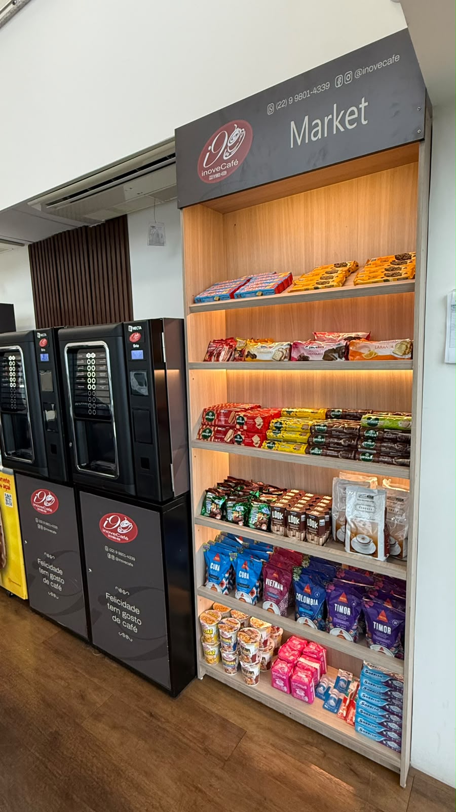 Prateleira de produtos de conveniência instalada ao lado de máquinas de café.